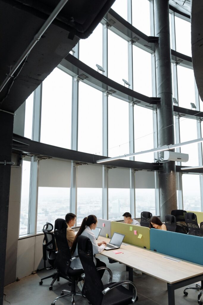 Spacious contemporary office space with employees working on laptops in a high-rise building.