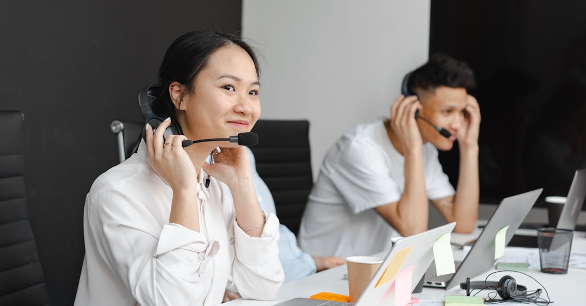 A diverse group of call center agents working with laptops and headsets in a modern office.